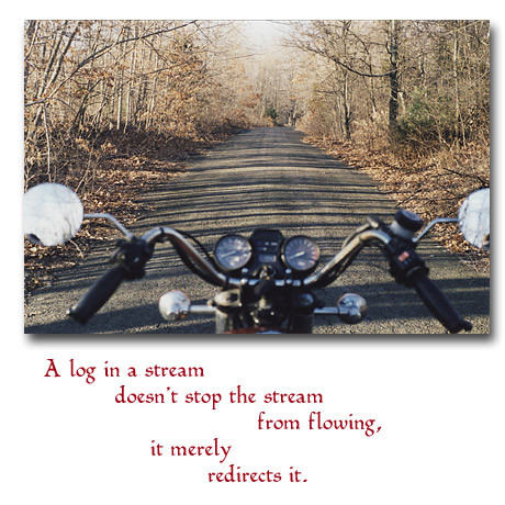 Looking over the handlebars of Tom's Suzuki 750L down a country road